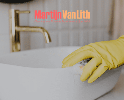 gloved hand cleaning the sink